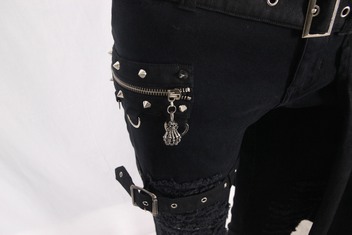 Close-up of black steampunk pants featuring zippers, studs, and kilt holes, perfect for punk fashion enthusiasts.