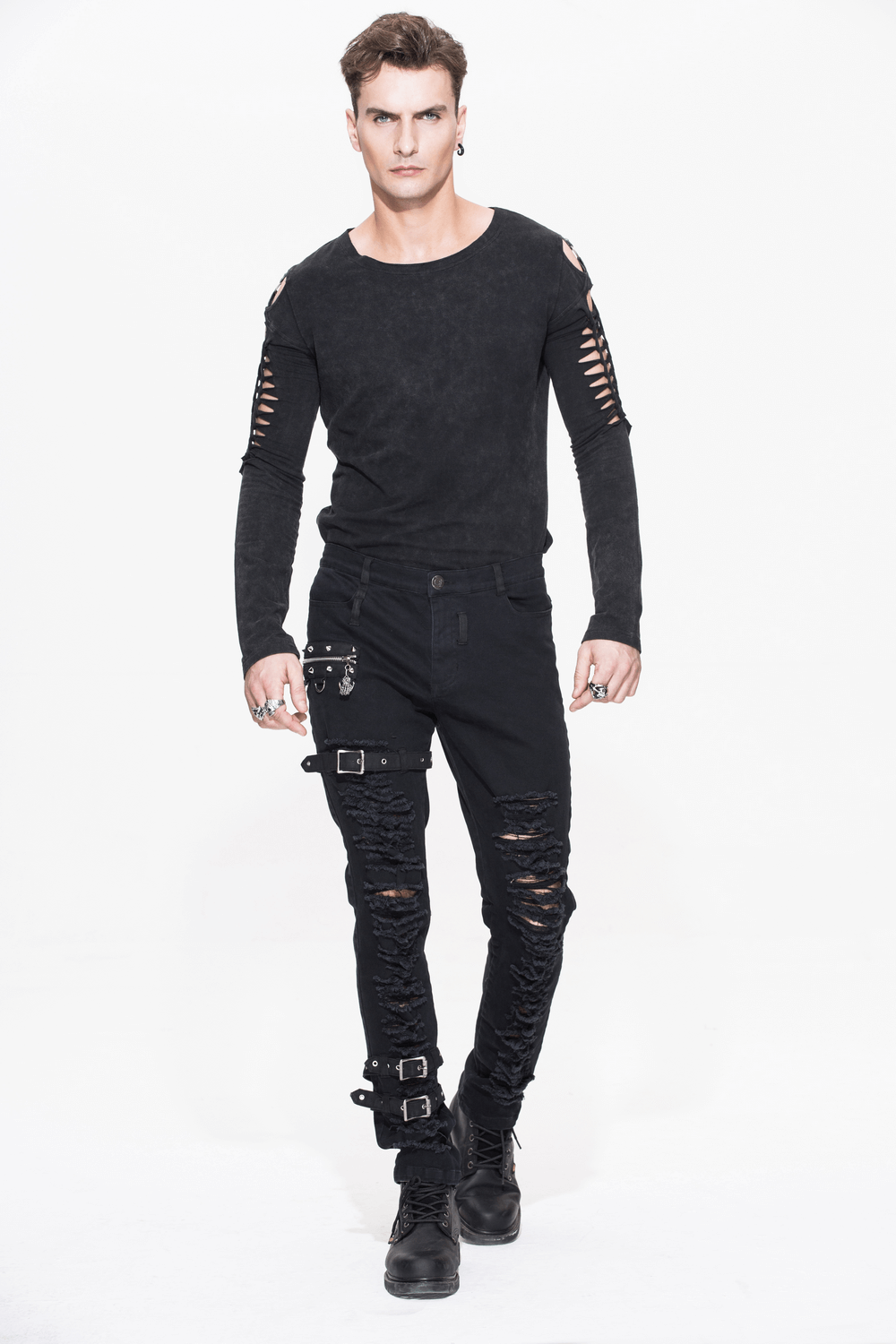 Stylish man in black ripped gothic pants and long sleeve shirt, showcasing edgy steampunk rock fashion.