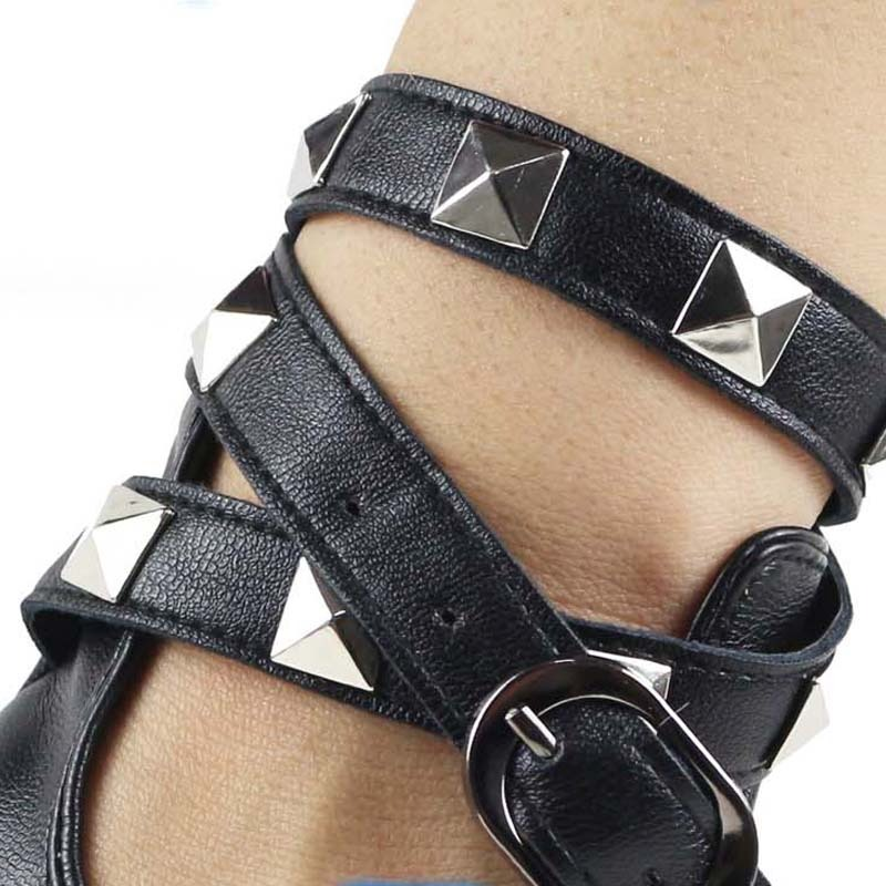 Close-up of steampunk fingerless gloves featuring pyramid studs and a stylish buckle strap for a punk rock look.