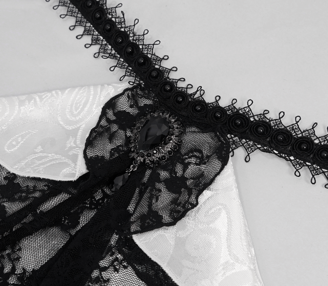 Close-up of a black lace tie collar with vintage embellishments on a white men's steampunk shirt.