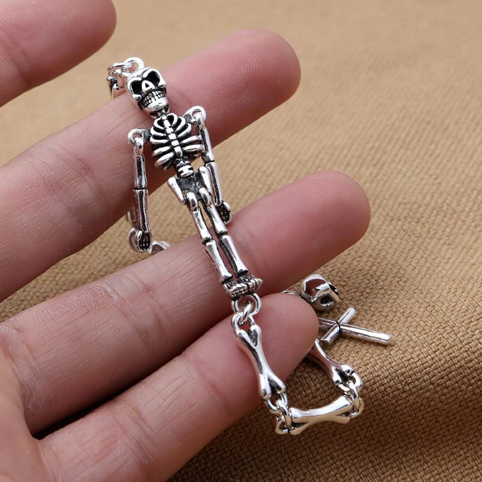 Close-up of a hand holding a chic unisex sterling silver skeleton bracelet in punk style.