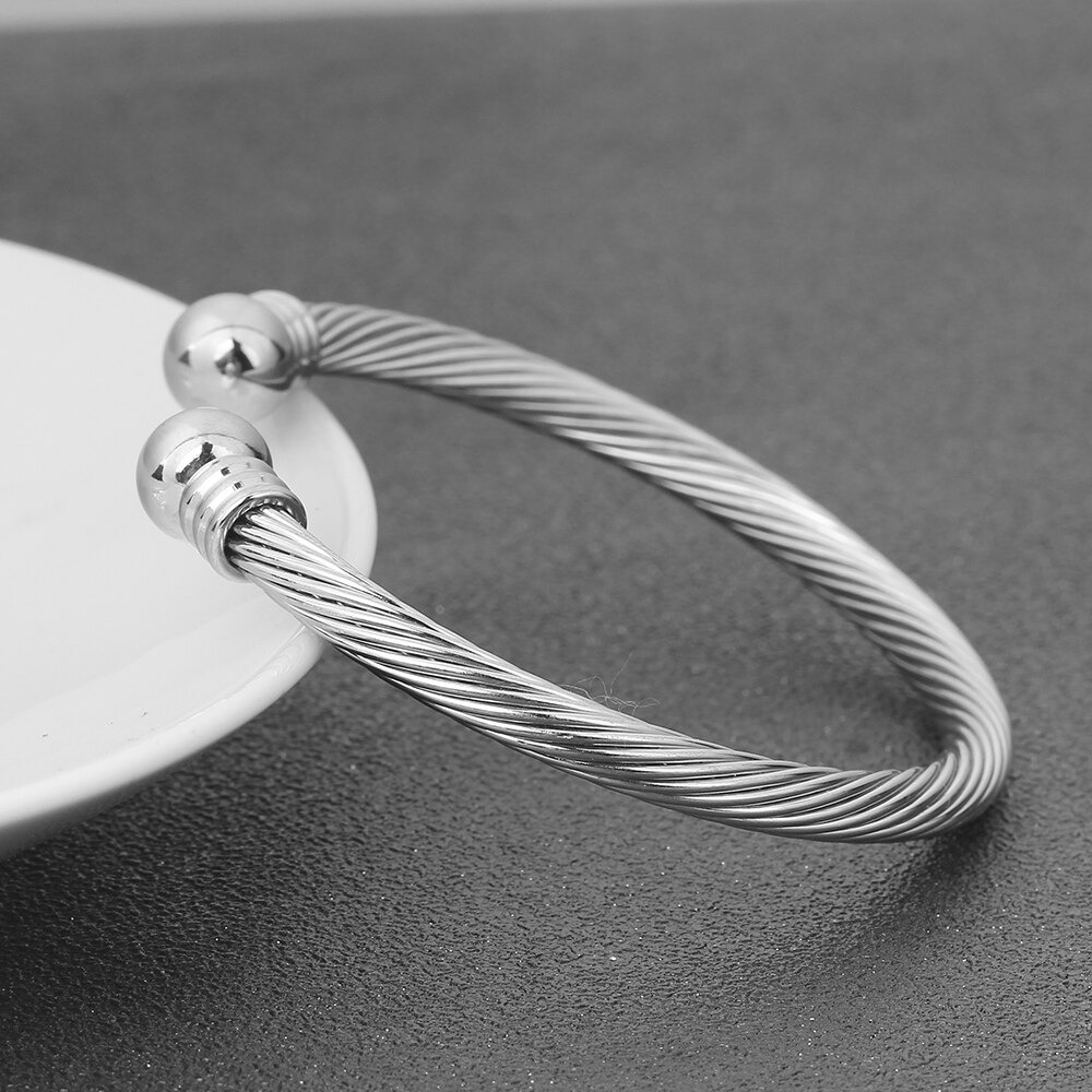 Stylish stainless steel bracelet for women, featuring a twisted design and silver finish, perfect for rock outfits.