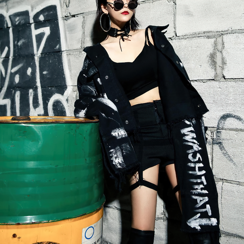 Women wearing a graffiti print jeans jacket, styled in streetwear fashion, against an urban backdrop.