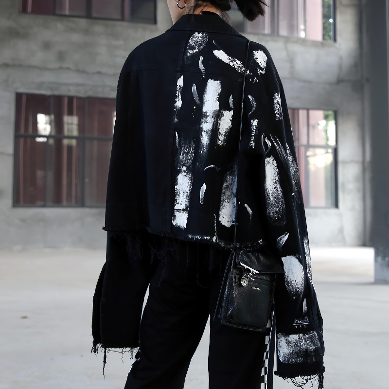 Stylish women's graffiti print jeans jacket in black with unique white designs for modern streetwear looks.