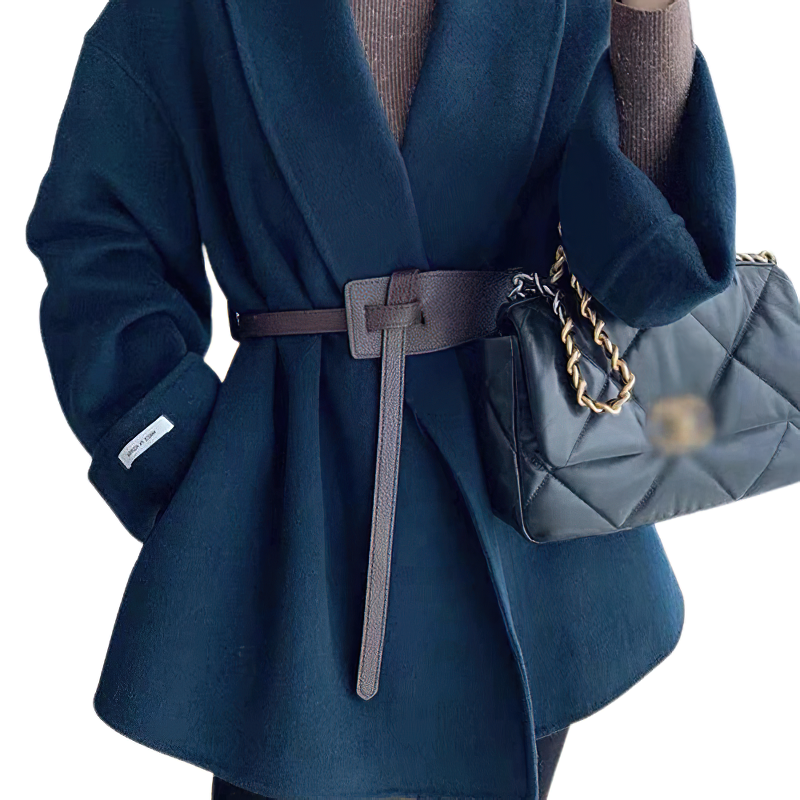 Stylish woman wearing a navy wide coat cinched with a brown PU leather belt, holding a chic black handbag.