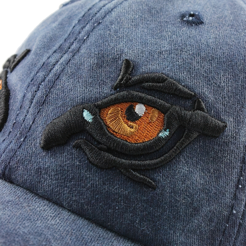 Close-up of embroidery detail on stylish unisex cotton baseball cap featuring an eagle eye design.