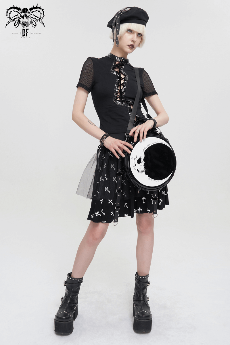 Gothic style model wearing a black outfit and carrying a stylish crescent moon skull handbag.