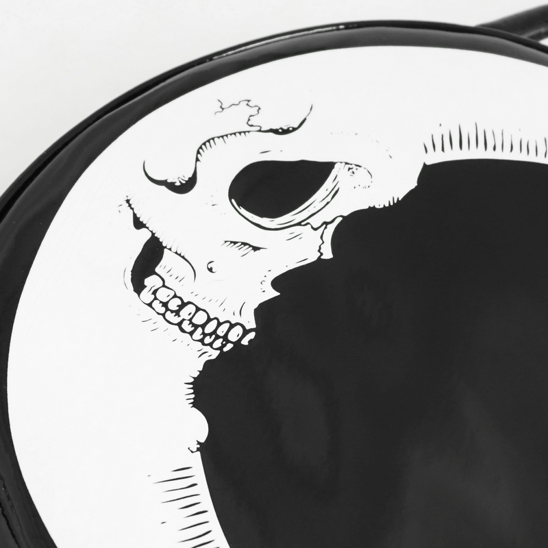 Close-up of a stylish crescent moon handbag with a detailed skull design, perfect gothic accessory for women.