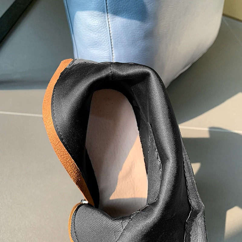 Close-up of stylish PU leather ankle boots showcasing soft interior lining and sleek design.