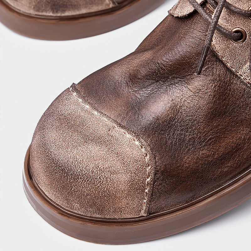 Close-up of stylish lace-up cowhide cowboy shoes for men, showcasing the soft leather texture and round toe design.
