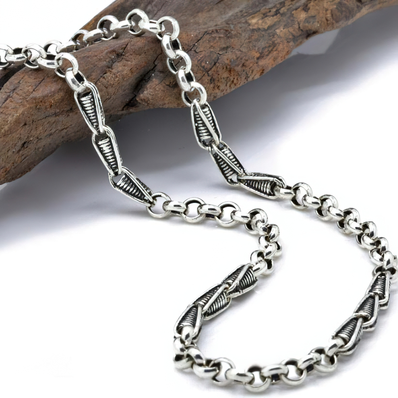 Stylish unisex sterling silver chain necklace resting on wooden surface, highlighting its modern design and quality craftsmanship.