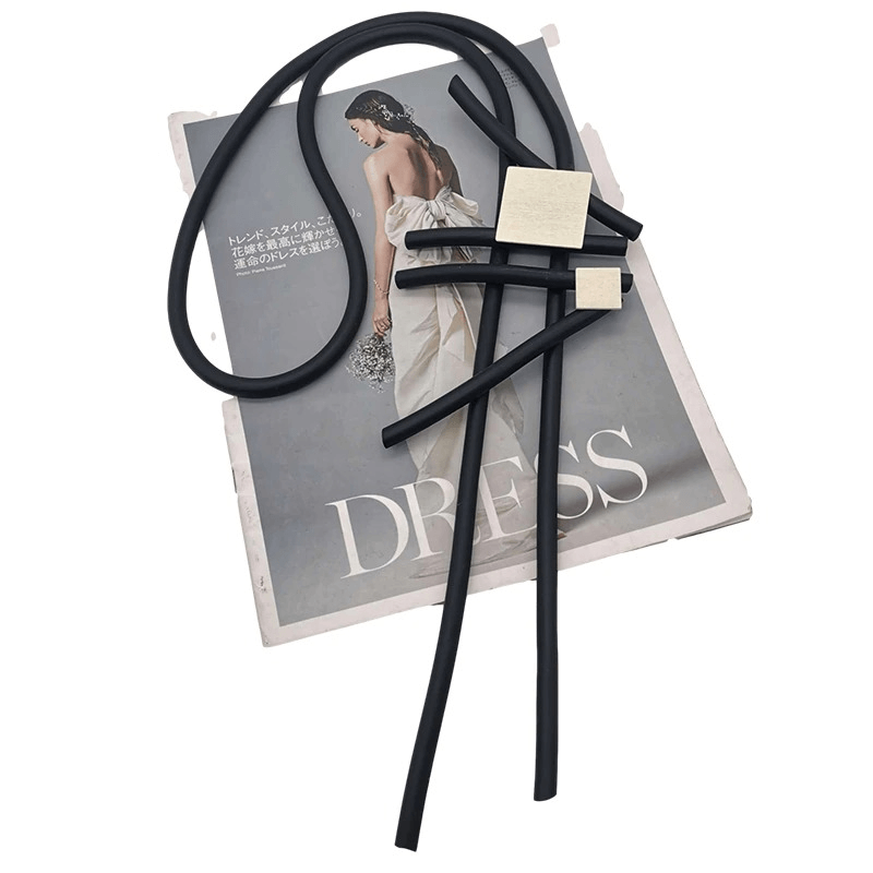 Stylish square wood pendant necklace on magazine titled 'DRESS', showcasing fashionable rubber accessories for women.