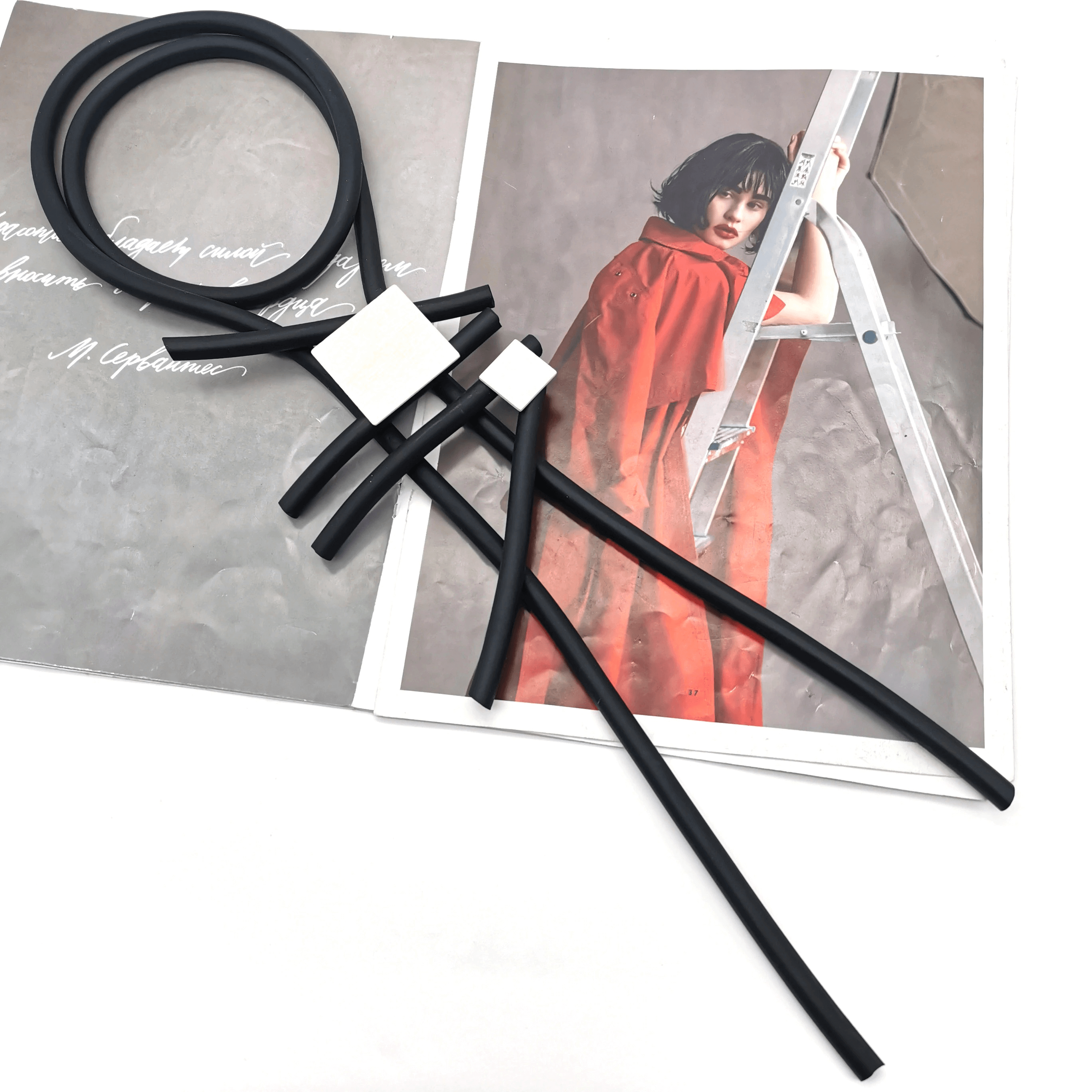 Stylish square wood pendant necklace with rubber accents on a stylish magazine background.