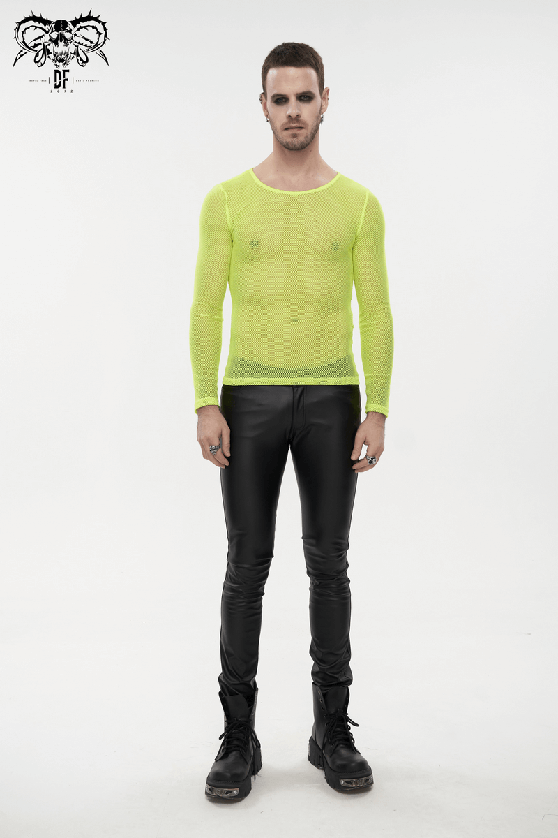 Stylish male model in a fluorescent yellow mesh long sleeve top paired with black pants, showcasing alternative fashion.