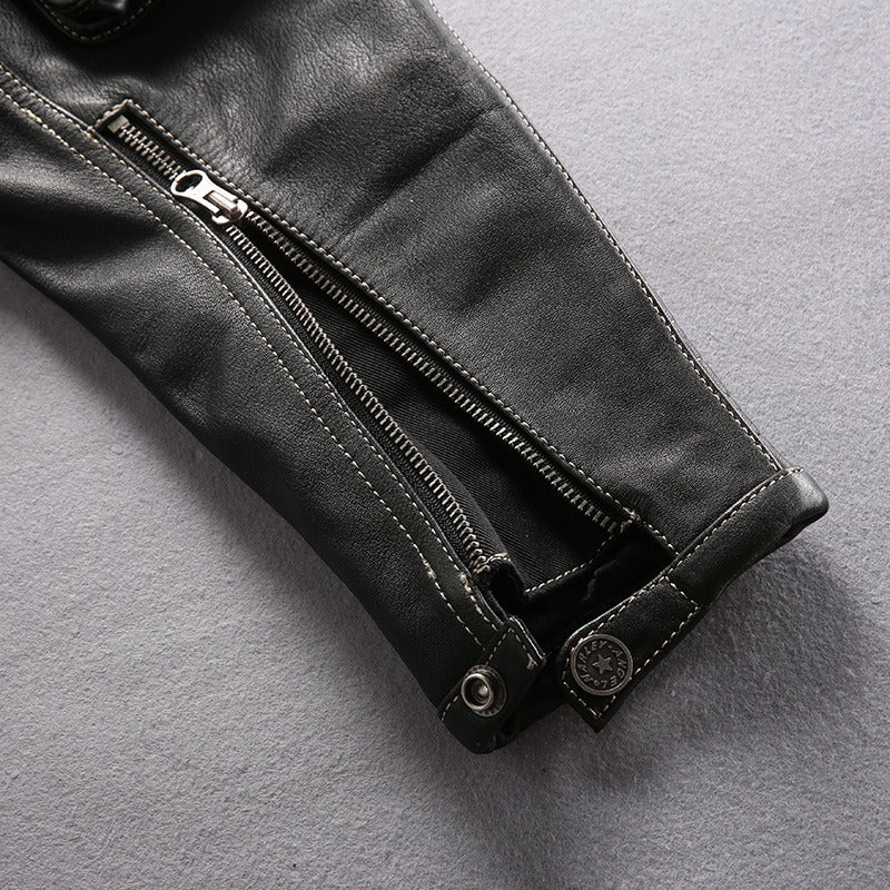 Close-up of stylish multi-pocket leather motorcycle jacket sleeve with zippers and rivet details.