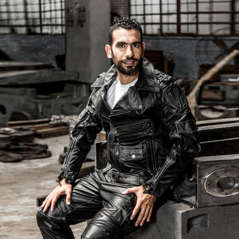 Stylish multi-pocket black leather motorcycle jacket worn by a man, showcasing classic biker style and functionality.