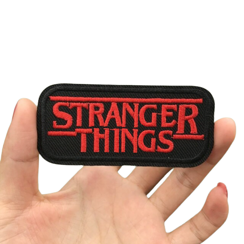 Unisex "Stranger Things" patch in rock style held by hand, perfect for alternative fashion and clothing decoration.