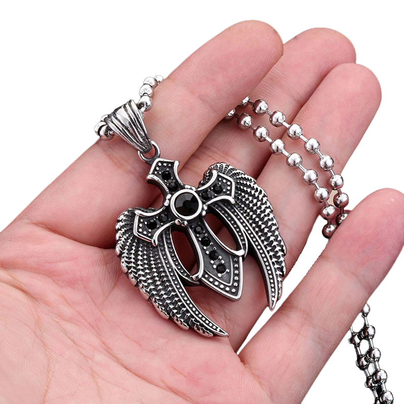 Unisex vintage stainless steel wing cross pendant with stones, gothic style, held in hand with chain.