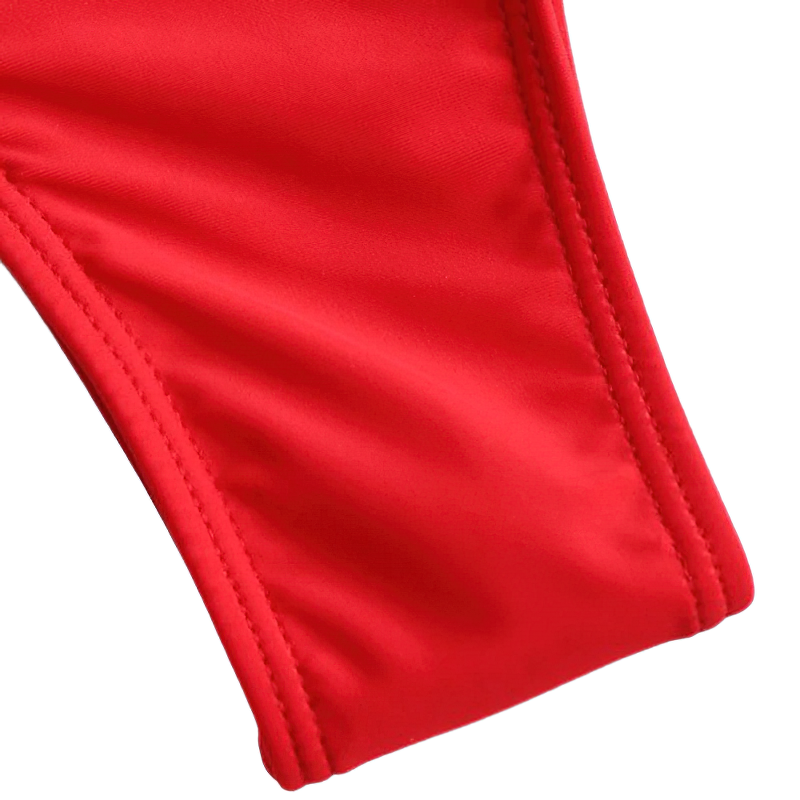 Close-up of vibrant red fabric showcasing the stylish design details of a one-piece women's monokini swimsuit.