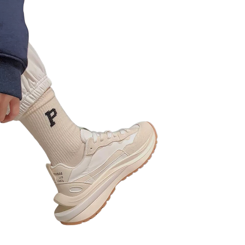 Fashionable chunky sneakers with a beige color scheme paired with stylish socks featuring letter P for a trendy look.
