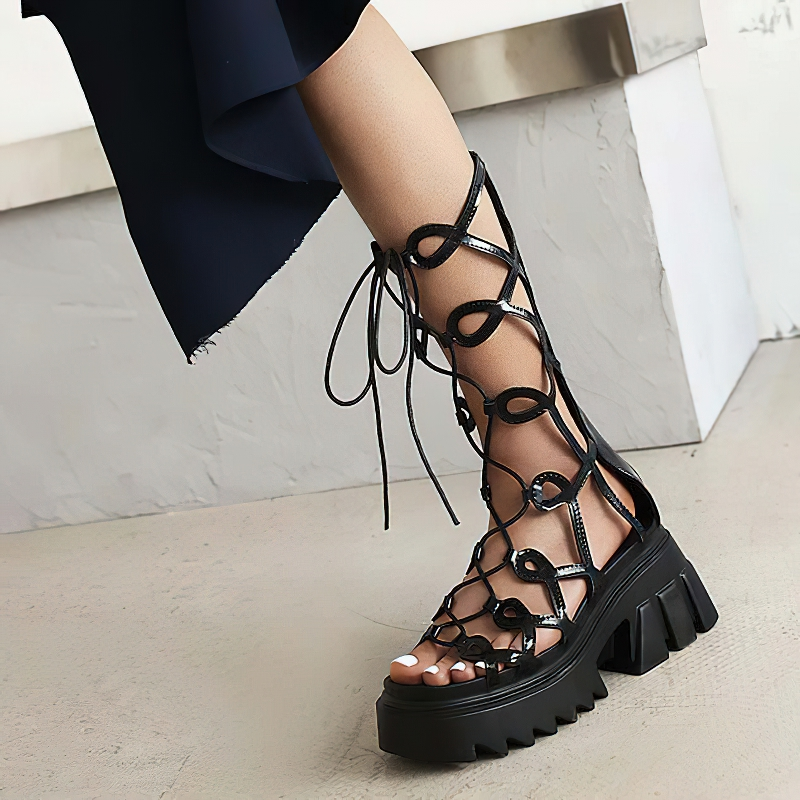Stylish black lace-up platform sandals with intricate cross straps for a trendy gothic summer look.
