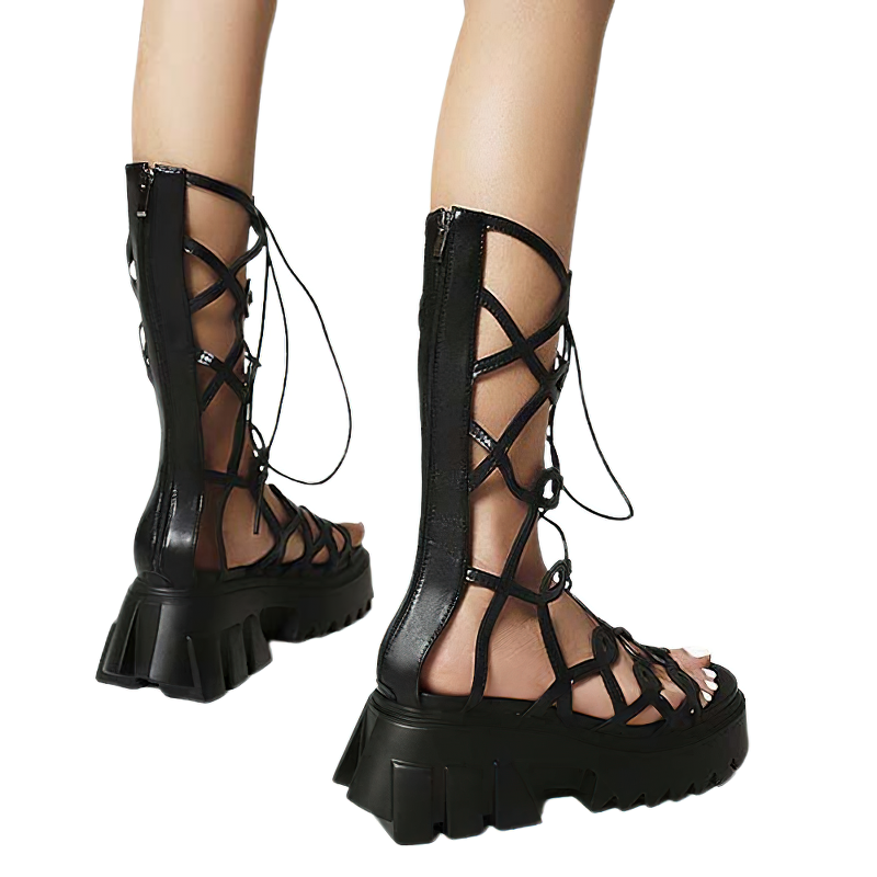 Stylish women's black gladiator sandals with thin cross straps and chunky sole for an alternative gothic fashion look.