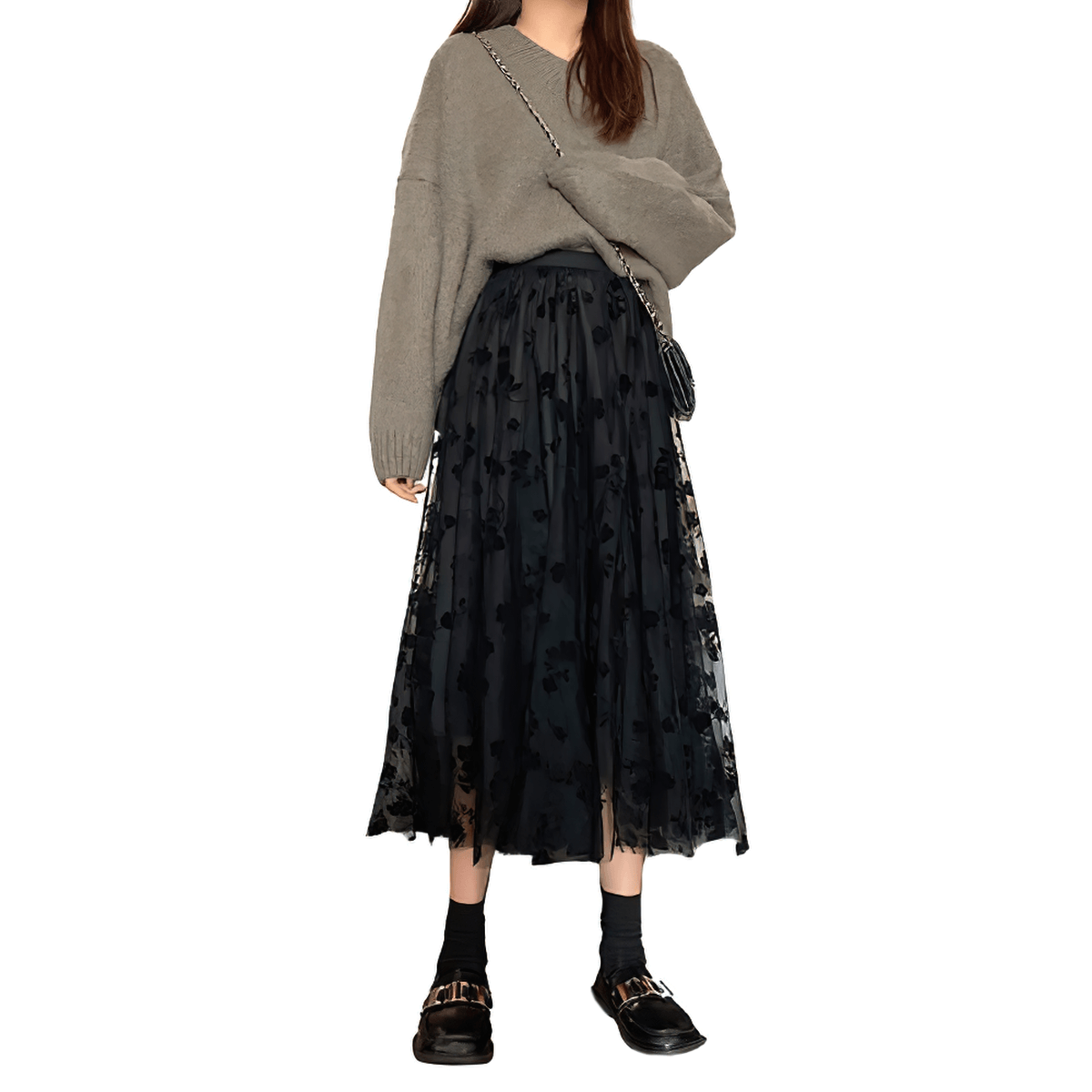 Stylish women's high waist skirt with embroidered flowers and tulle overlay, paired with a cozy sweater and chic shoes.