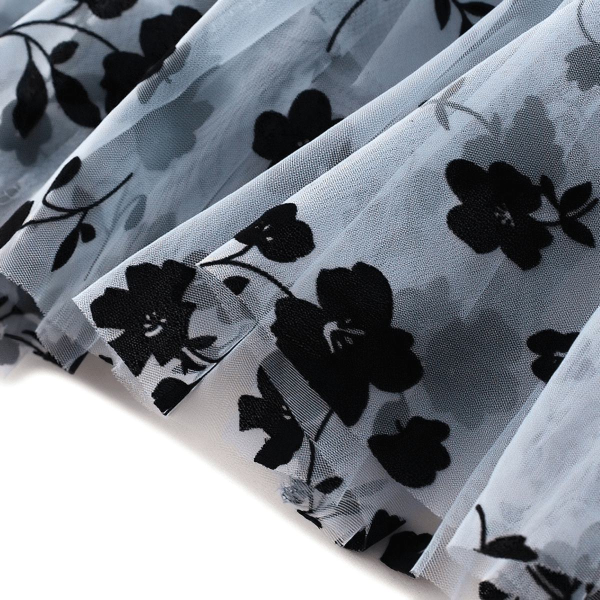 Close-up of stylish mesh tulle skirt with black floral embroidery, showcasing elegant ruffles and delicate details.