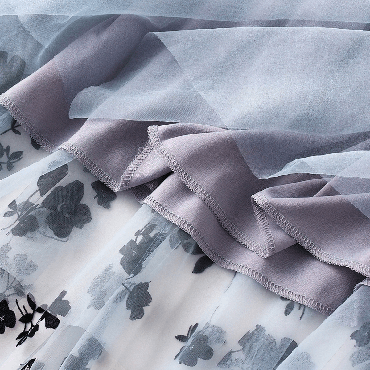 Close-up of stylish women's high waist skirt featuring delicate floral embroidery in mesh tulle layers.