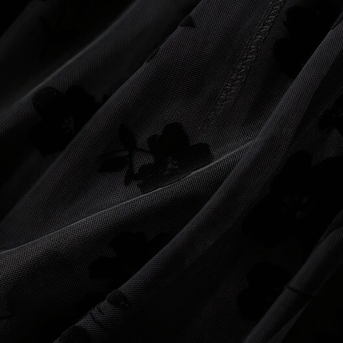 Close-up of stylish black mesh tulle fabric with embroidered floral details, perfect for an elegant women's high waist skirt.