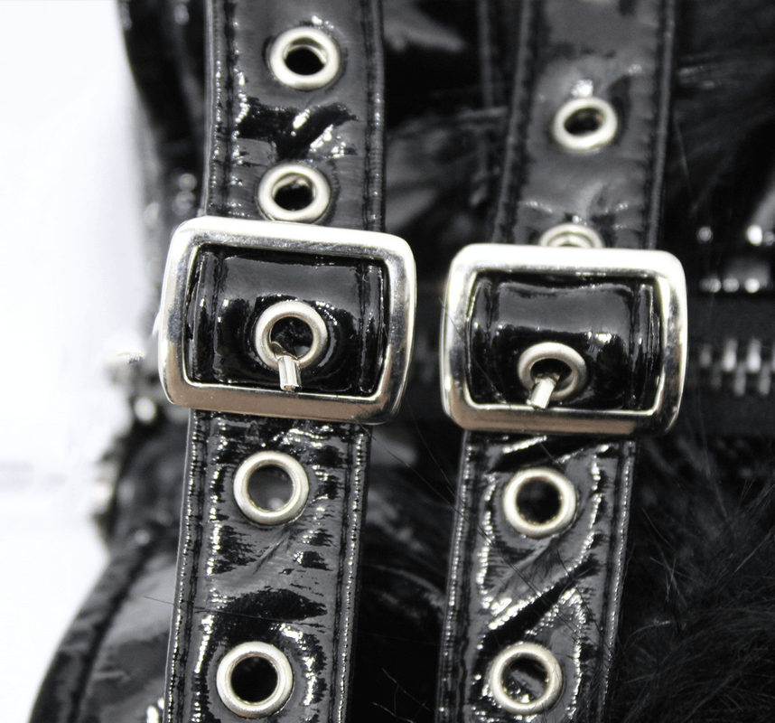 Close-up of shiny black PU leather straps with buckles and grommets on a fashionable women's jacket.