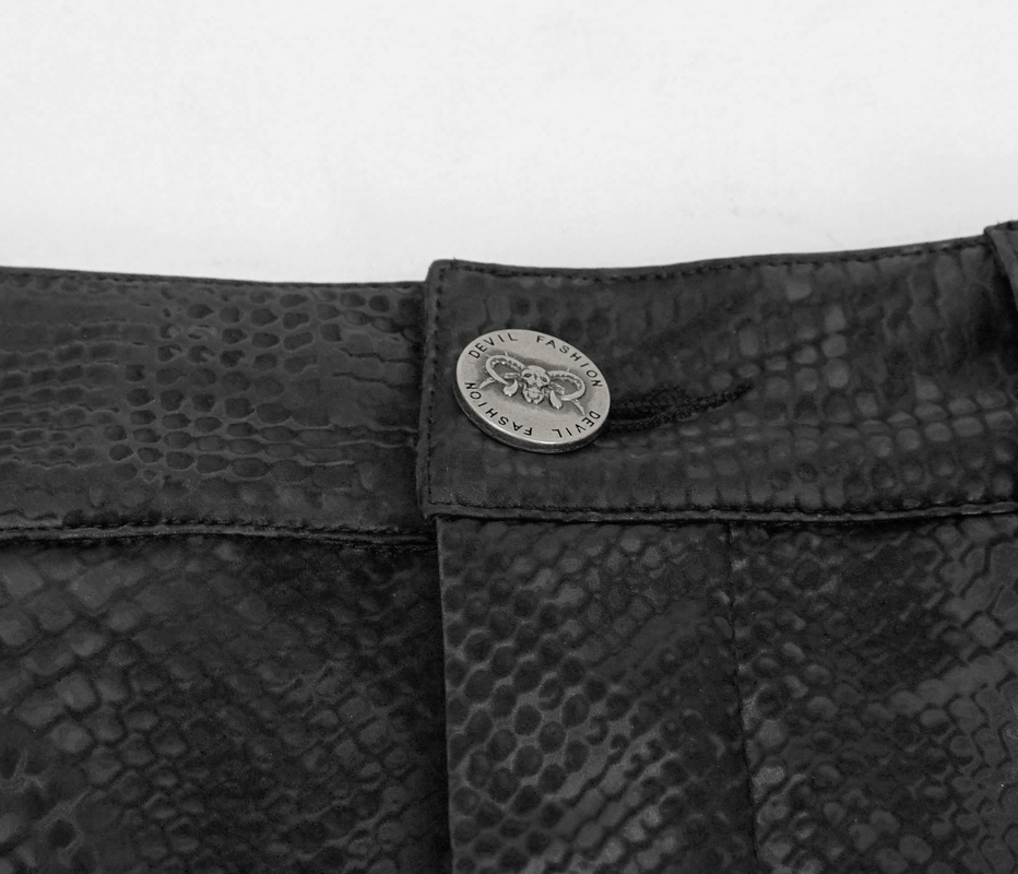 Close-up of stylish women's snakeskin skirt waistband featuring a decorative button and textured print.