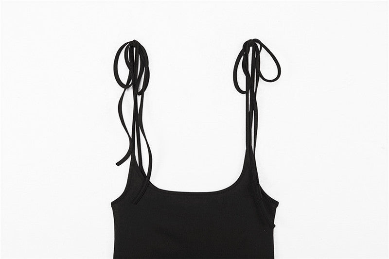 Close-up of shoulder straps on a women's black skirt, showcasing alternative fashion style and unique design.