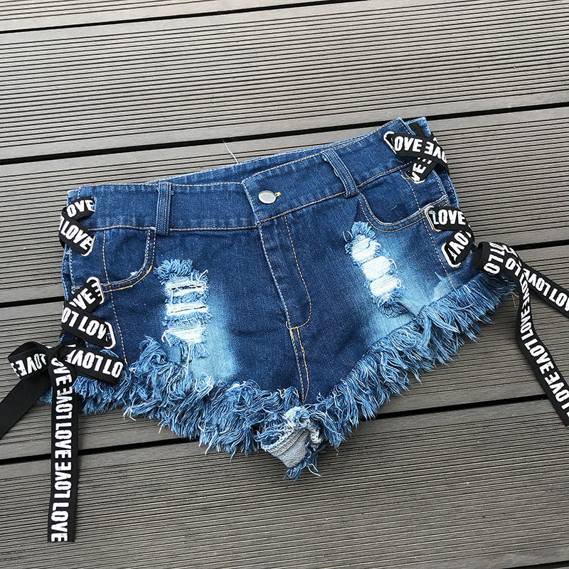 Blue denim summer shorts with lace-up sides and distressed details, perfect for a rock-style look.