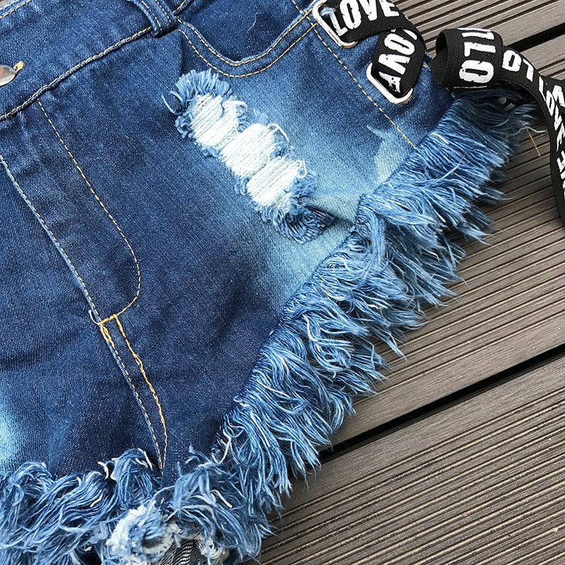 Summer women denim short shorts with ripped details and fringe hem, perfect for a playful rock style.