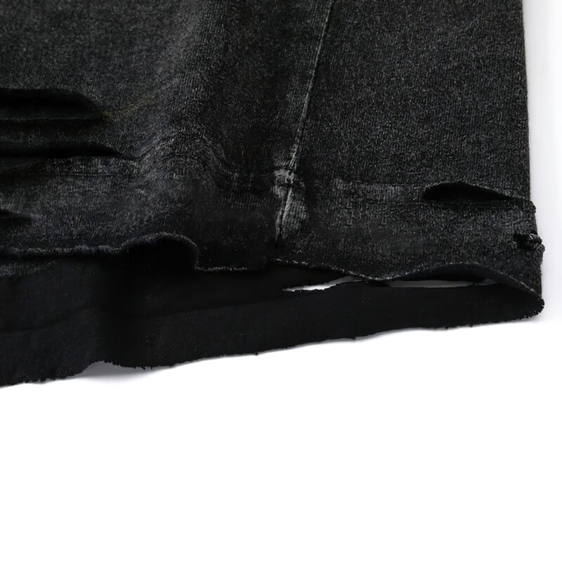 Close-up of a black ripped tank top showing distressed fabric details, perfect for a gothic fashion look.