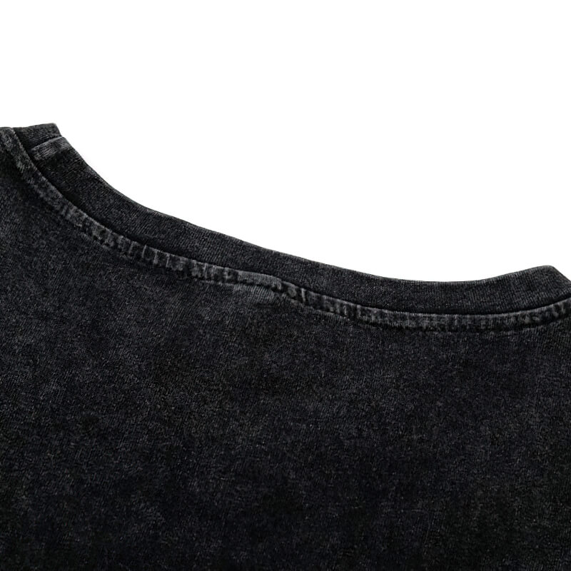 Close-up of the neckline of a black ripped tank top, showcasing its stylish gothic design and modern cut.