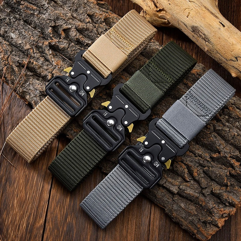 Tactical nylon belts with metal multifunctional buckles in tan, green, and gray colors on wooden surface.