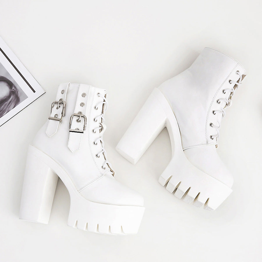 Stylish white lace-up ankle boots with thick heels and decorative buckles, perfect for rocker outfits.
