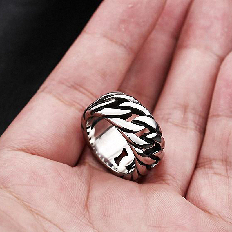 Titanium steel biker chain ring held in hand, showcasing its polished stainless steel design and unique chain shape.