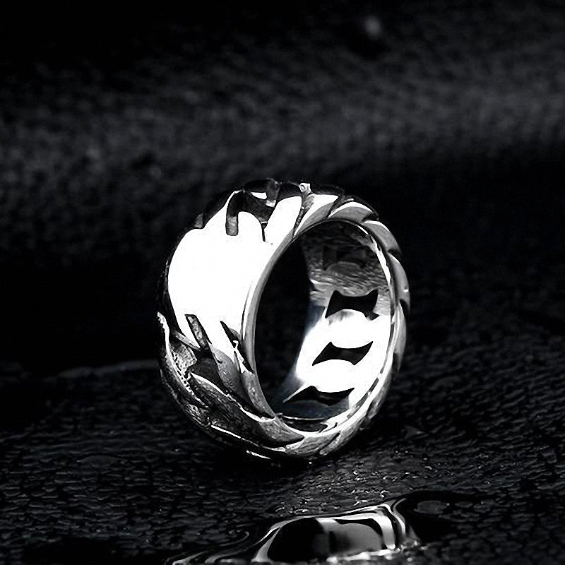 Elegant titanium steel biker chain ring with a unique design, shining against a dark wet surface, perfect for rock accessories.