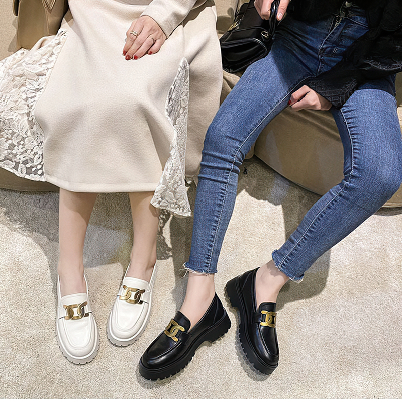Stylish thick-soled loafers in black and white leather with gold chain detail, perfect for casual outfits.