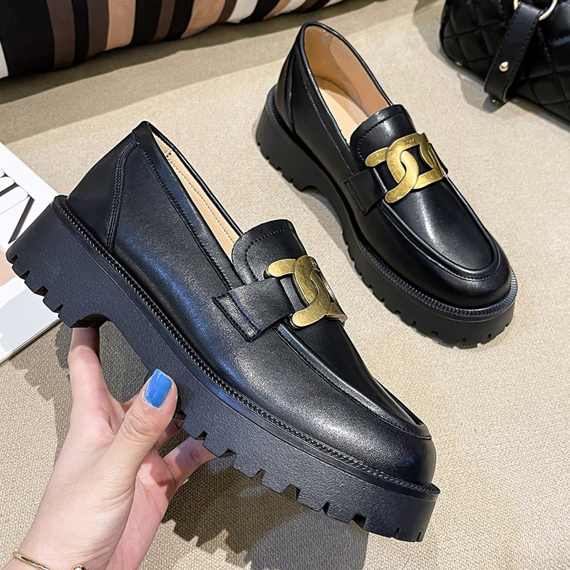 Stylish thick-soled black leather loafers for women featuring a gold chain accent detail.