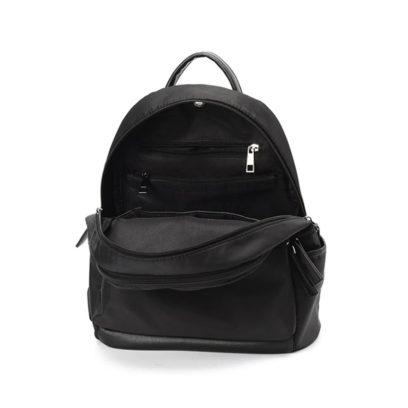 Interior view of a trendy black casual backpack for women with multiple pockets and zipper compartments.