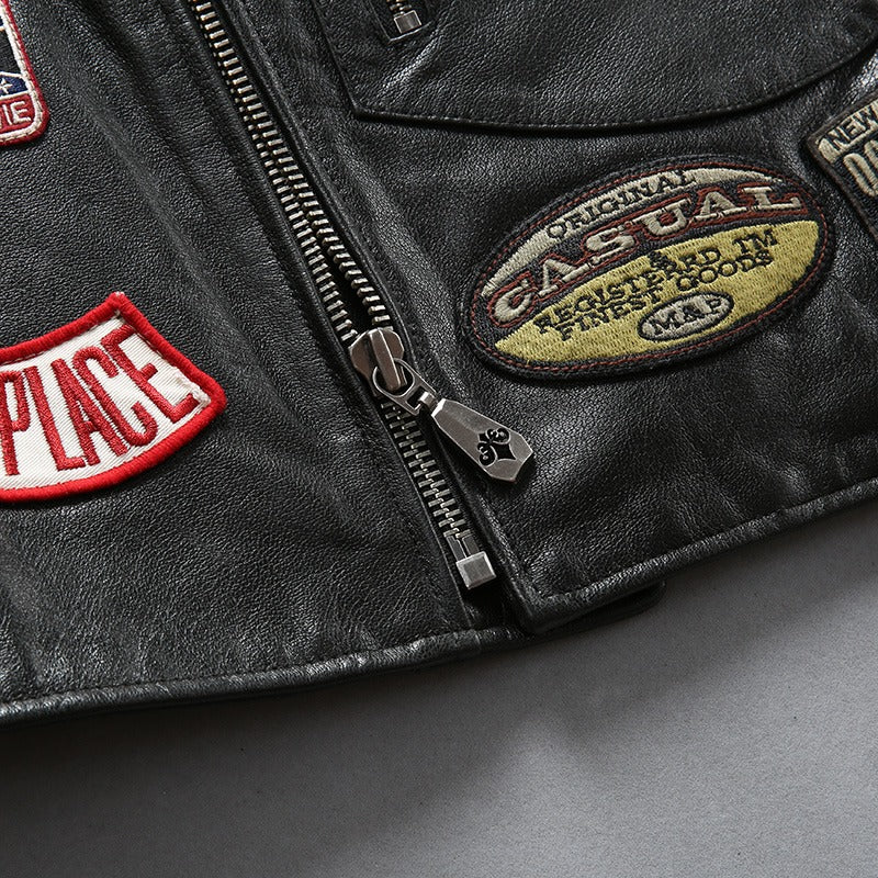 Close-up of black cowhide leather biker vest with colorful patches and zippers, showcasing stylish Rock Fashion details.