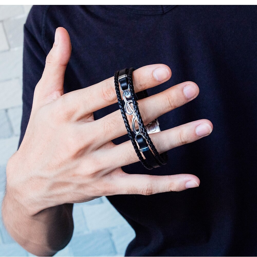 Close-up of a hand wearing unique musical symbol bracelets, showcasing casual and stylish PU leather accessories.