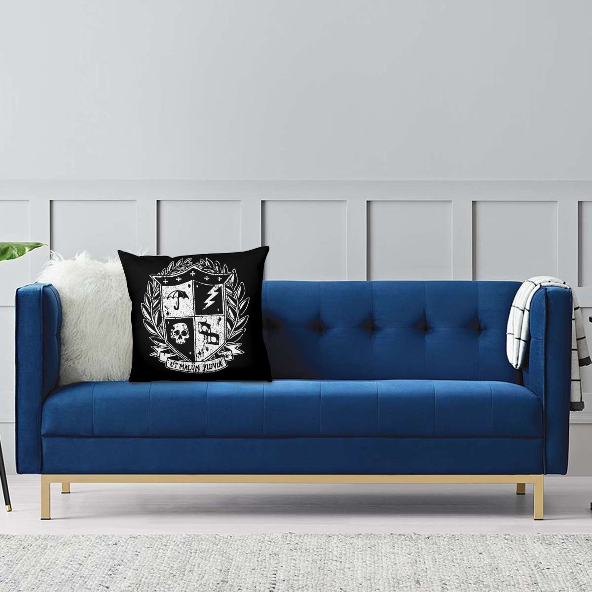 Stylish blue sofa with unique Umbrella Academy decorative pillow featuring a bold crest design.