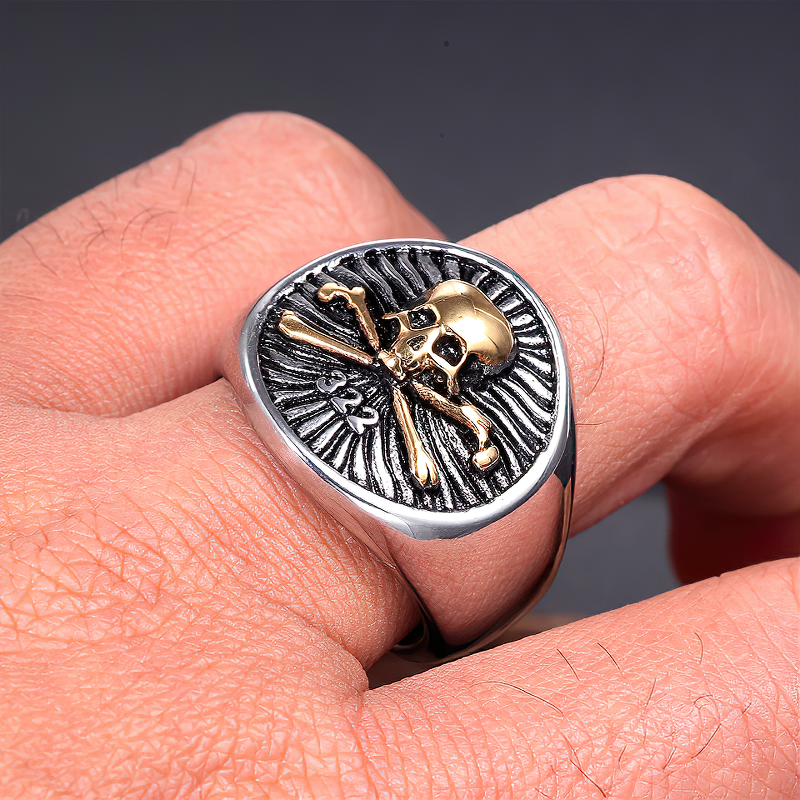 Close-up of a unique skull pirate ring in stainless steel with gold accents, perfect for a gothic style.