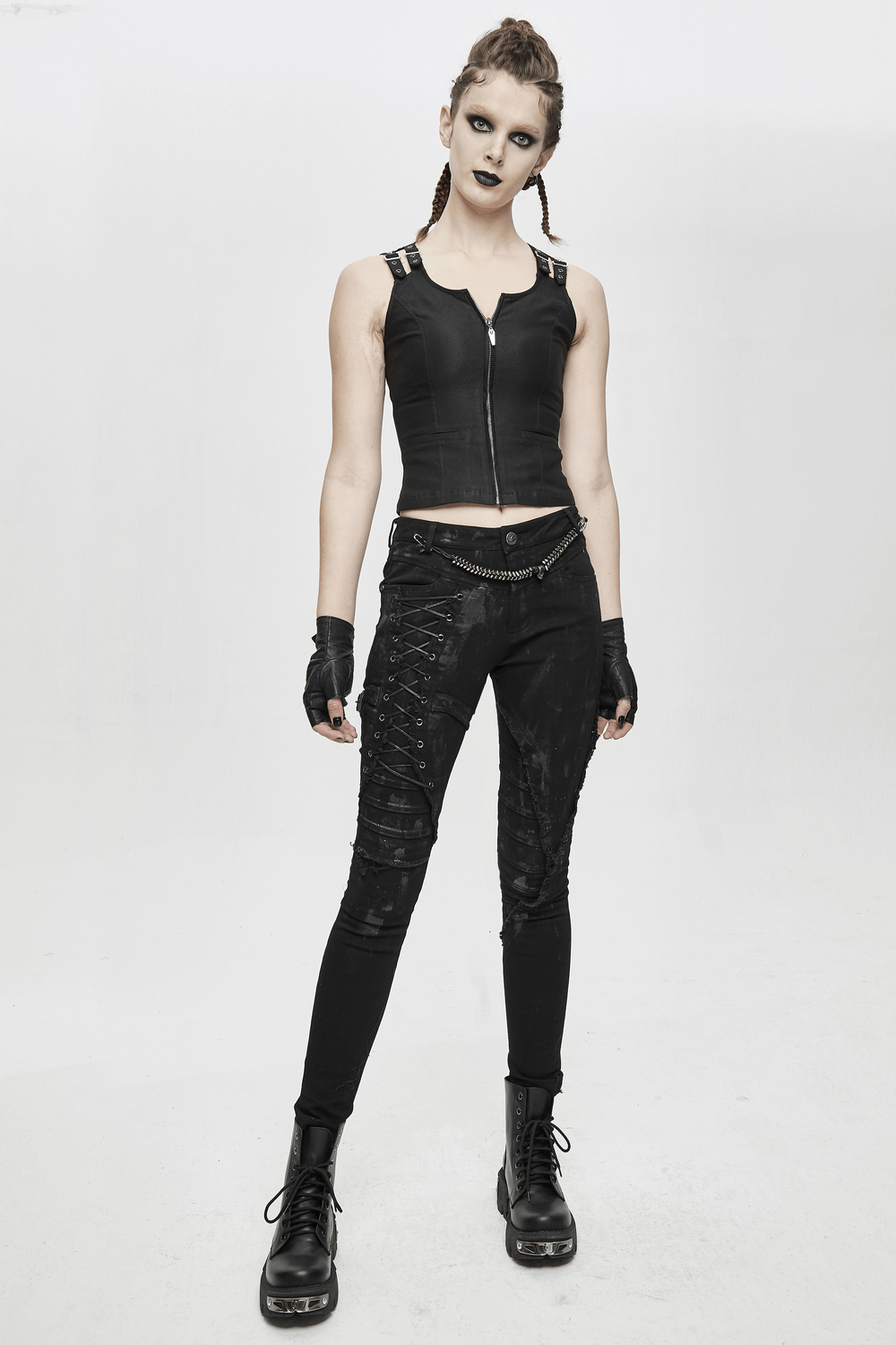 Confident woman wearing unique steampunk skinny black denim trousers and a fitted top, showcasing an edgy streetwear look.