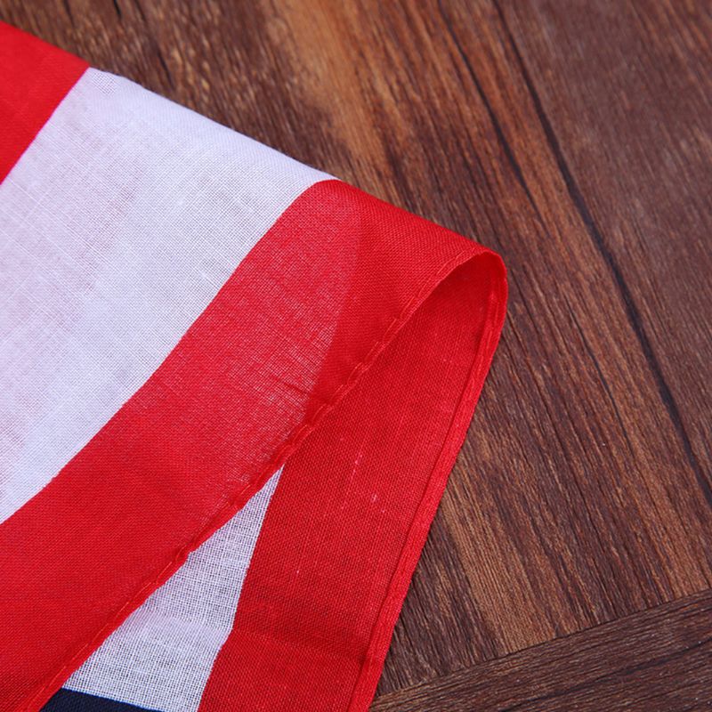 Close-up of a red and white striped unisex cotton bandana, featuring an American flag design on wood background.